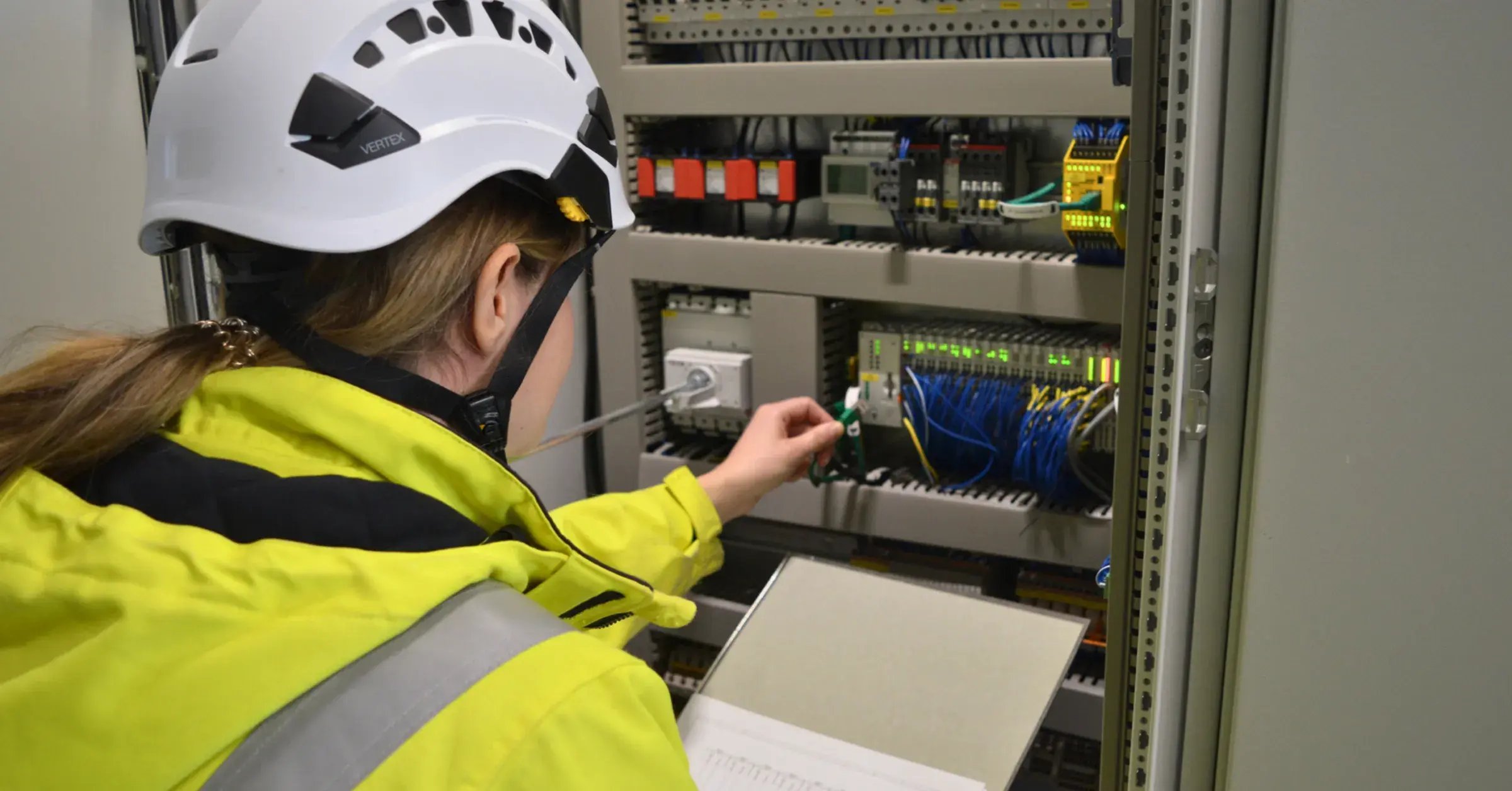 Mitarbeiterin von INTILION steht vor einem Energiespeicher