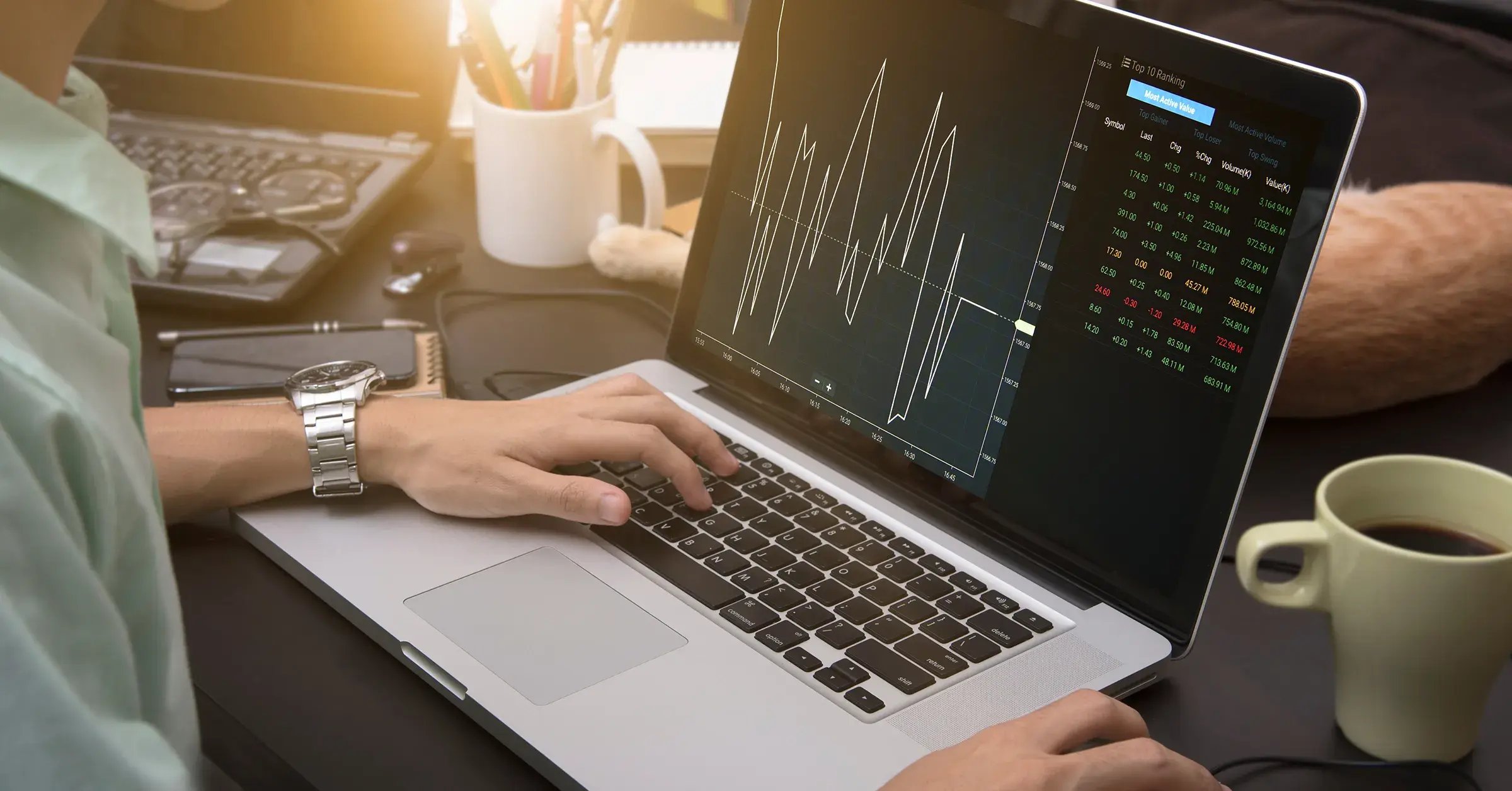 Mann arbeitet am Laptop mit Grafik, die variable Stromtarife und Strompreisschwankungen visualisiert