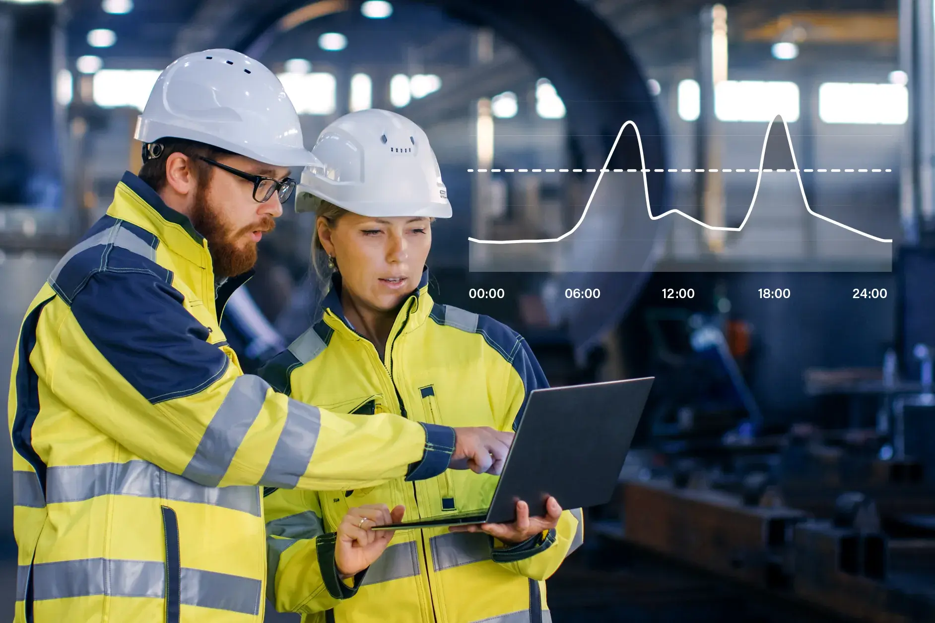Industrie Mitarbeitende analysieren Lastspitzen am Laptop in einer Produktionshalle als Beispiel für Peakshaving und optimierte Energieverbräuche in der Industrie.