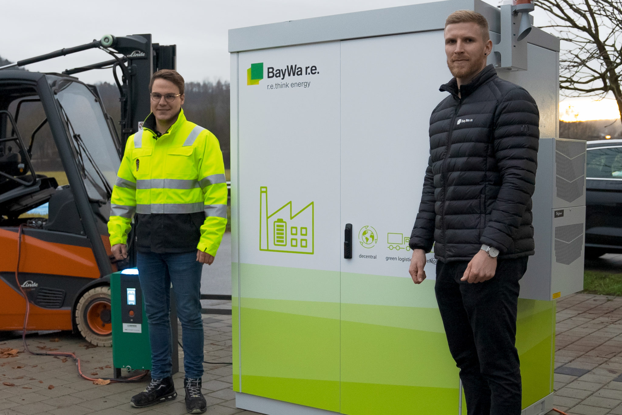 Matthias Giller (INTILION GmbH) und Peter Hechle (Baywa r.e. Energy Systems) vor Gewerbespeicher und Gabelstapler